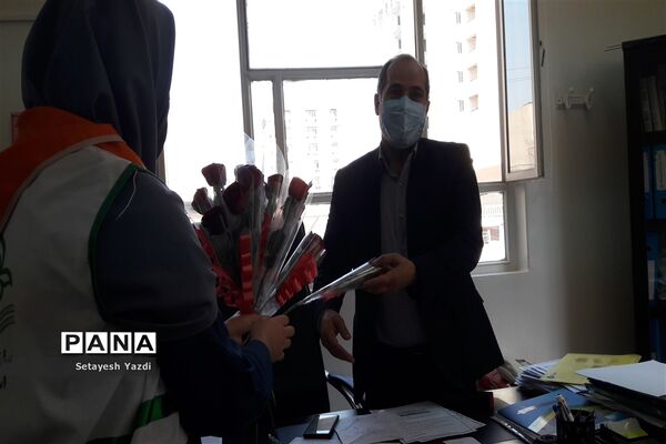 توزیع گل توسط دانش آموز پیشتاز دبیرستان هیات امنایی پاینده بمناسبت میلاد پیامبر (ص)