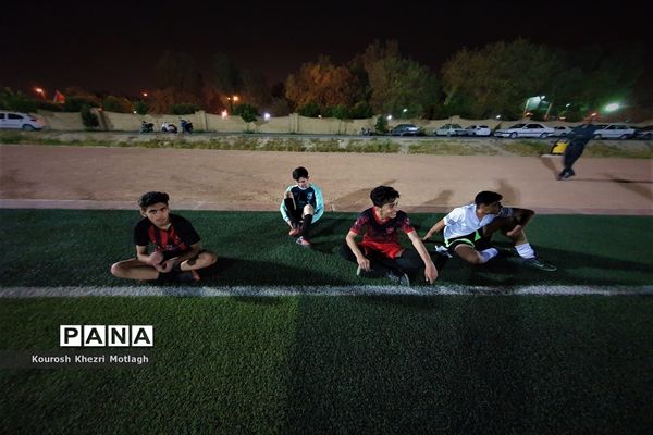 زنگ ورزش دانش‌آموزان دبیرستان شهید دستغیب کازرون  بعد از افطار در زمین چمن