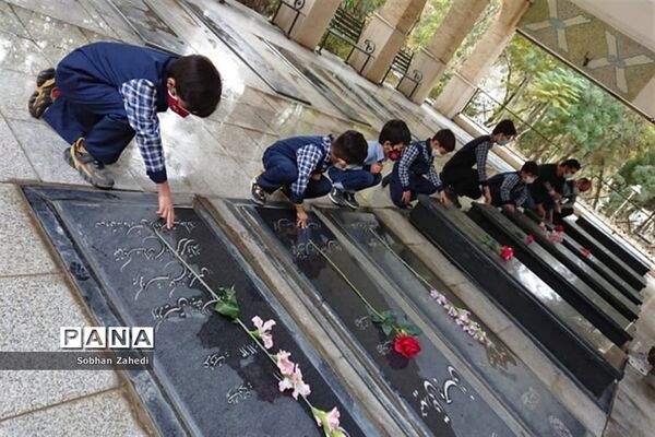 غبارروبی مزارشهدا توسط دانش‌آموزان رودهن در دهه فجر