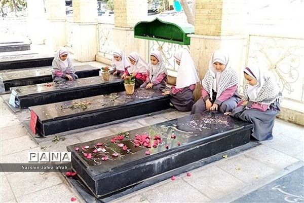 غبارروبی مزار شهدا توسط دانش‌آموزان رودهن در هفته بسیج